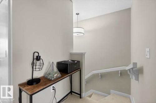 The property features a staircase with carpeted treads and a white handrail - 16656 14 Avenue, Edmonton, AB - Indoor