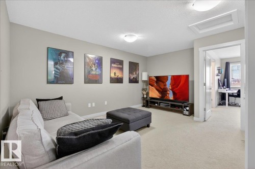 This versatile room features light-colored carpeting, recessed lighting, and a doorway leading to an additional space - 16656 14 Avenue, Edmonton, AB - Indoor