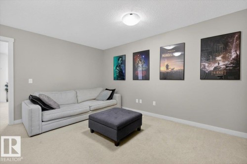 This room features light grey walls and light-colored carpeting, creating a bright and neutral atmosphere - 16656 14 Avenue, Edmonton, AB - Indoor Photo Showing Living Room