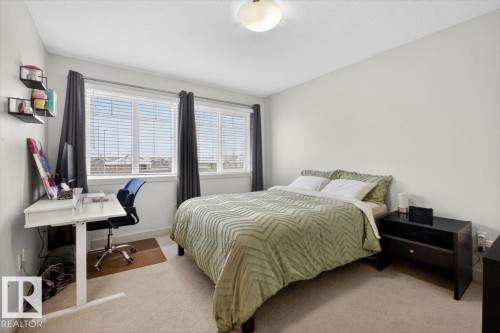 This room features light-colored walls and carpeting, creating a bright and airy atmosphere - 16656 14 Avenue, Edmonton, AB - Indoor Photo Showing Bedroom