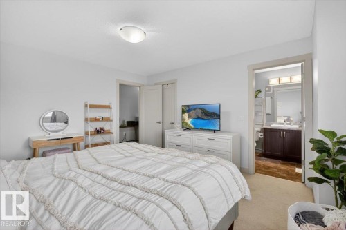 The bedroom features light-colored carpeting, white walls, and a ceiling light fixture - 16656 14 Avenue, Edmonton, AB - Indoor Photo Showing Bedroom