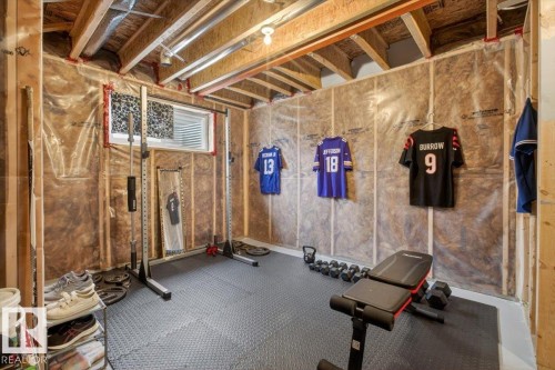 The unfinished basement features exposed wood beams, insulation, and a window for natural light - 16656 14 Avenue, Edmonton, AB - Indoor Photo Showing Basement