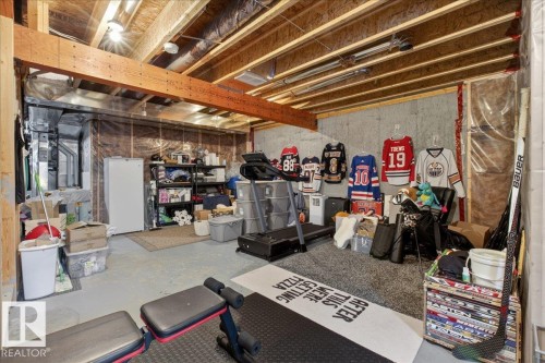 Unfinished basement featuring exposed wooden beams, concrete walls, and ample space for storage or future development - 16656 14 Avenue, Edmonton, AB - Indoor Photo Showing Basement