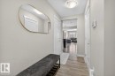 The property features a bright hallway with light-colored walls, wood-look flooring, and a contemporary overhead light fixture - 16656 14 Avenue, Edmonton, AB  - Indoor Photo Showing Other Room 