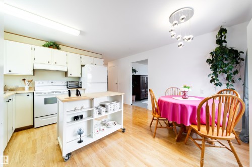 The kitchen features white cabinetry, a white range, and a white refrigerator - 1104 35 Street, Edmonton, AB - Indoor