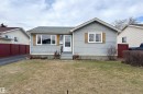 Ranch-style residence featuring light blue siding with white trim, a dark asphalt shingle roof, and a mature front lawn - 1104 35 Street, Edmonton, AB  - Outdoor 