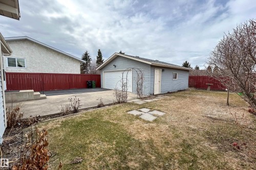 Detached garage with white overhead door, gray siding, and a side access door - 1104 35 Street, Edmonton, AB - Outdoor