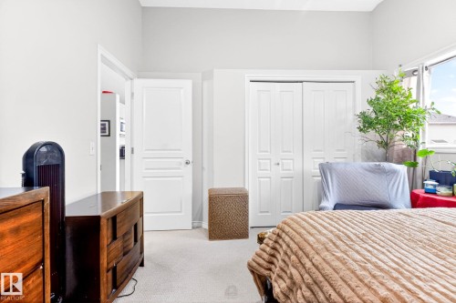 This room features light-colored walls and carpeting, a window with natural light, and a double-door closet - 20147 48 Avenue, Edmonton, AB - Indoor Photo Showing Bedroom