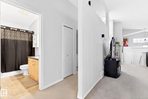 The property features light-colored carpeting, a bright bathroom with a light wood vanity, and white walls throughout - 20147 48 Avenue, Edmonton, AB - Indoor