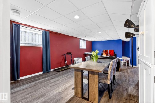 Versatile space featuring wood-look flooring, a drop ceiling with recessed lighting, and windows providing natural light - 20147 48 Avenue, Edmonton, AB - Indoor Photo Showing Other Room