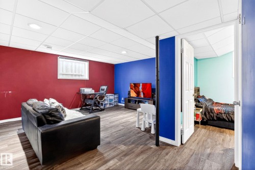 Finished basement living area featuring wood-look flooring, a drop ceiling with recessed lighting, and a single window - 20147 48 Avenue, Edmonton, AB - Indoor