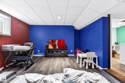 The property features a versatile room with durable laminate flooring and a drop ceiling with recessed lighting - 20147 48 Avenue, Edmonton, AB - Indoor