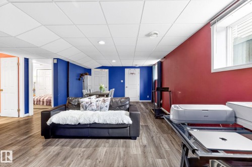 Living area featuring wood-look flooring, white ceiling tiles, and a window with blinds - 20147 48 Avenue, Edmonton, AB - Indoor Photo Showing Bedroom