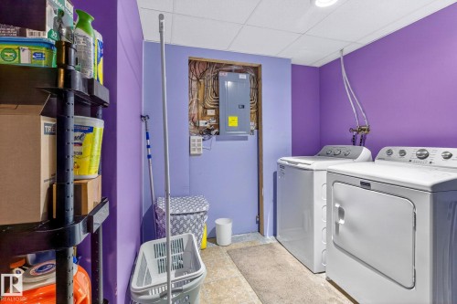 The laundry area features a washer and dryer, a utility sink, and a drop ceiling - 20147 48 Avenue, Edmonton, AB - Indoor Photo Showing Laundry Room