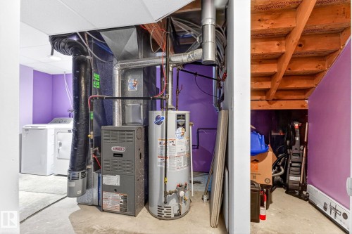 The property features a utility area with a water heater, furnace, and laundry appliances - 20147 48 Avenue, Edmonton, AB - Indoor Photo Showing Basement