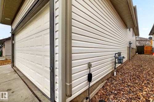 The property features a garage with a panelled door and light-colored siding - 20147 48 Avenue, Edmonton, AB - Outdoor With Exterior