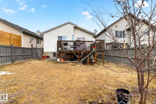 The property features a spacious backyard with a wooden deck, a wooden privacy fence, and a mature tree - 20147 48 Avenue, Edmonton, AB - Outdoor With Deck Patio Veranda