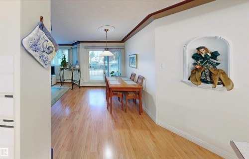 This dining area features hardwood floors and a glass sliding door leading to an outdoor space - 31 9914 80 Avenue, Edmonton, AB - Indoor