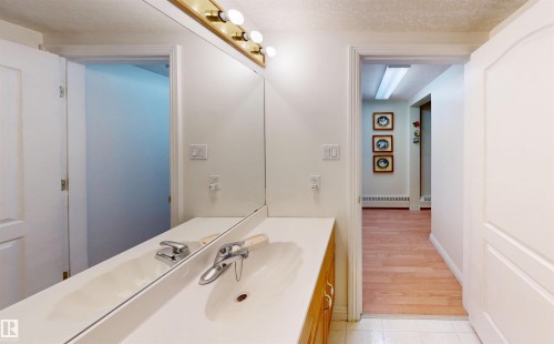 Bathroom vanity featuring a large mirror, a chrome faucet, and ample counter space - 31 9914 80 Avenue, Edmonton, AB - Indoor Photo Showing Bathroom