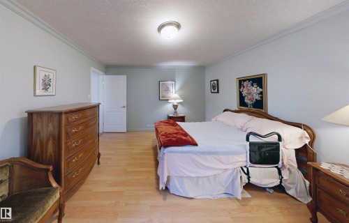 This bedroom features light wood flooring, light-colored walls, and a ceiling light fixture - 31 9914 80 Avenue, Edmonton, AB - Indoor Photo Showing Bedroom