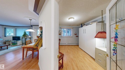 Living area featuring wood flooring, a dining area with a chandelier, and windows with blinds - 31 9914 80 Avenue, Edmonton, AB - Indoor Photo Showing Other Room