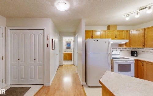 The kitchen features light wood cabinetry, white appliances, and a white tiled backsplash - 31 9914 80 Avenue, Edmonton, AB - Indoor Photo Showing Kitchen