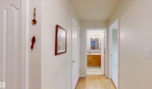 The property features light-colored walls and hardwood flooring throughout the hallway - 31 9914 80 Avenue, Edmonton, AB - Indoor Photo Showing Other Room
