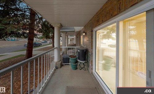 The property features a balcony with white railings and columns, offering views of the street - 31 9914 80 Avenue, Edmonton, AB - Outdoor With Exterior
