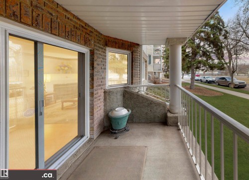 The property features a balcony with a white railing, a white pillar, and a brick exterior wall - 31 9914 80 Avenue, Edmonton, AB - Outdoor With Balcony With Exterior
