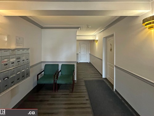 Common area featuring wall sconces, ceiling lighting, and a textured floor - 31 9914 80 Avenue, Edmonton, AB - Indoor Photo Showing Other Room