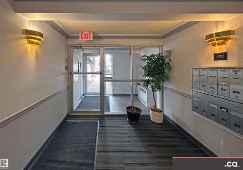 The property features a well-maintained entrance area with patterned flooring and wall sconces providing ambient lighting - 31 9914 80 Avenue, Edmonton, AB - Indoor Photo Showing Other Room