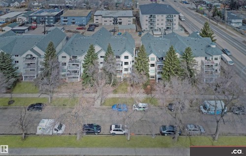The property features multiple buildings with white exteriors and grey roofs, complemented by balconies - 31 9914 80 Avenue, Edmonton, AB - 