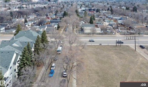 This aerial view showcases the surrounding neighborhood, featuring residential properties with various rooflines and mature trees lining the streets - 31 9914 80 Avenue, Edmonton, AB - Outdoor With View