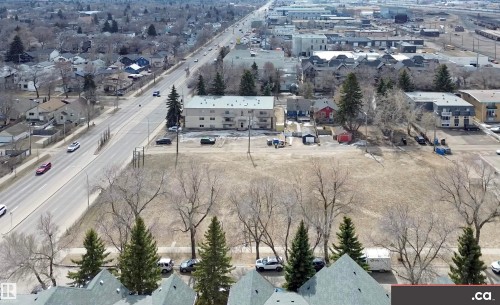 Aerial view of the surrounding neighborhood showcasing residential properties, a main road with vehicles, and a large open field - 31 9914 80 Avenue, Edmonton, AB - Outdoor With View