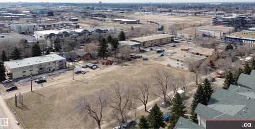 Aerial view of the property and surrounding urban landscape, showcasing nearby residential buildings and open land - 31 9914 80 Avenue, Edmonton, AB - Outdoor With View