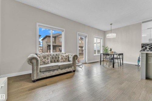 The property features light-colored walls and wood flooring throughout - 32 1703 16 Avenue, Edmonton, AB - Indoor Photo Showing Living Room
