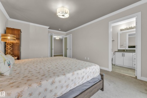 The bedroom features a neutral color palette, carpeted flooring, and a ceiling-mounted light fixture - 32 1703 16 Avenue, Edmonton, AB - Indoor Photo Showing Bedroom