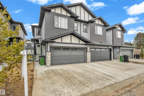 Exterior view of the property showcasing a dark gray siding facade with white trim accents and stone detailing - 32 1703 16 Avenue, Edmonton, AB - Outdoor