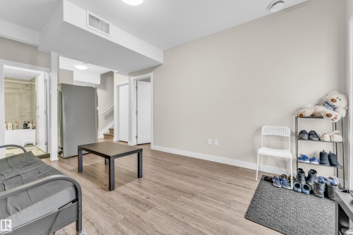 The property features light-colored walls and wood-look flooring throughout, creating a bright and cohesive aesthetic - 32 1703 16 Avenue, Edmonton, AB - Indoor