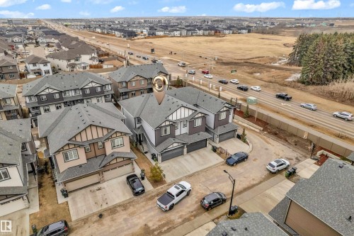 Aerial view showcasing the property's location within a residential area, featuring a two-story home with an attached garage and a paved driveway - 32 1703 16 Avenue, Edmonton, AB - Outdoor With View