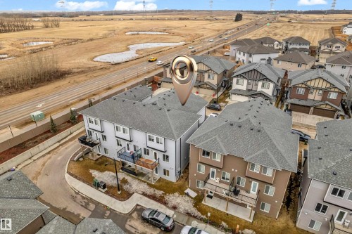 Aerial view of the property and surrounding neighbourhood, featuring a paved road, and properties with grey roofs - 32 1703 16 Avenue, Edmonton, AB - Outdoor