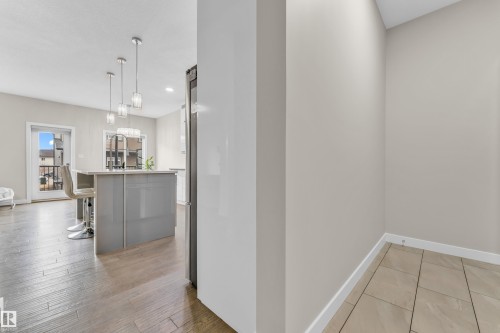 The kitchen features a center island with a sink and pendant lighting, and stainless steel appliances - 32 1703 16 Avenue, Edmonton, AB - Indoor