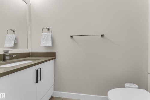 Bathroom featuring a vanity with a light-colored countertop, a white rectangular sink, and a modern chrome faucet - 32 1703 16 Avenue, Edmonton, AB - Indoor Photo Showing Bathroom