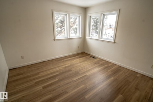 This room features light wood-look flooring and two windows providing natural light - 5209 49 Ave, St. Paul Town, AB - Indoor Photo Showing Other Room