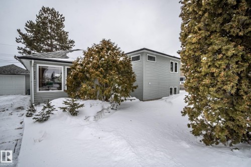 The property features light gray siding, a dark gray roof, and a prominent front window - 5209 49 Ave, St. Paul Town, AB - Outdoor