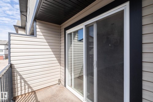 This property features a private balcony with a concrete floor, a metal railing, and light-colored siding - 1403 Cunningham Drive, Edmonton, AB - Outdoor With Exterior
