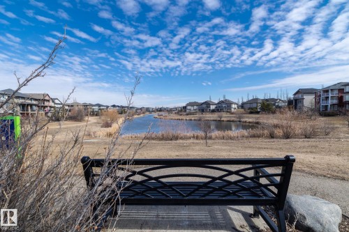 The property is situated within a community featuring a pond, surrounded by residential buildings - 1403 Cunningham Drive, Edmonton, AB - Outdoor With View