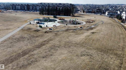 This aerial view captures the surrounding neighborhood, highlighting residential properties and a public park area - 1403 Cunningham Drive, Edmonton, AB - Outdoor With View