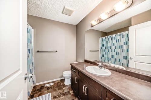 The bathroom features a vanity with a sink, a mirror, and overhead lighting - 8 13838 166Ave, Edmonton, AB - Indoor Photo Showing Bathroom