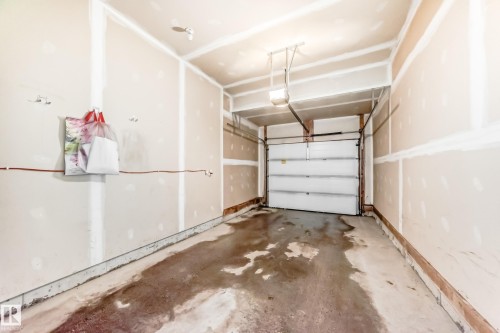 The property includes a garage with a roll-up door and a concrete floor - 8 13838 166Ave, Edmonton, AB - Indoor Photo Showing Garage
